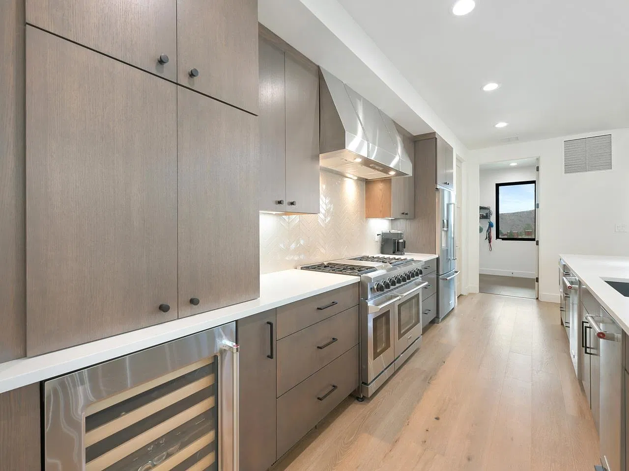 Kitchen with wood cabinets, range hood and wine fridge