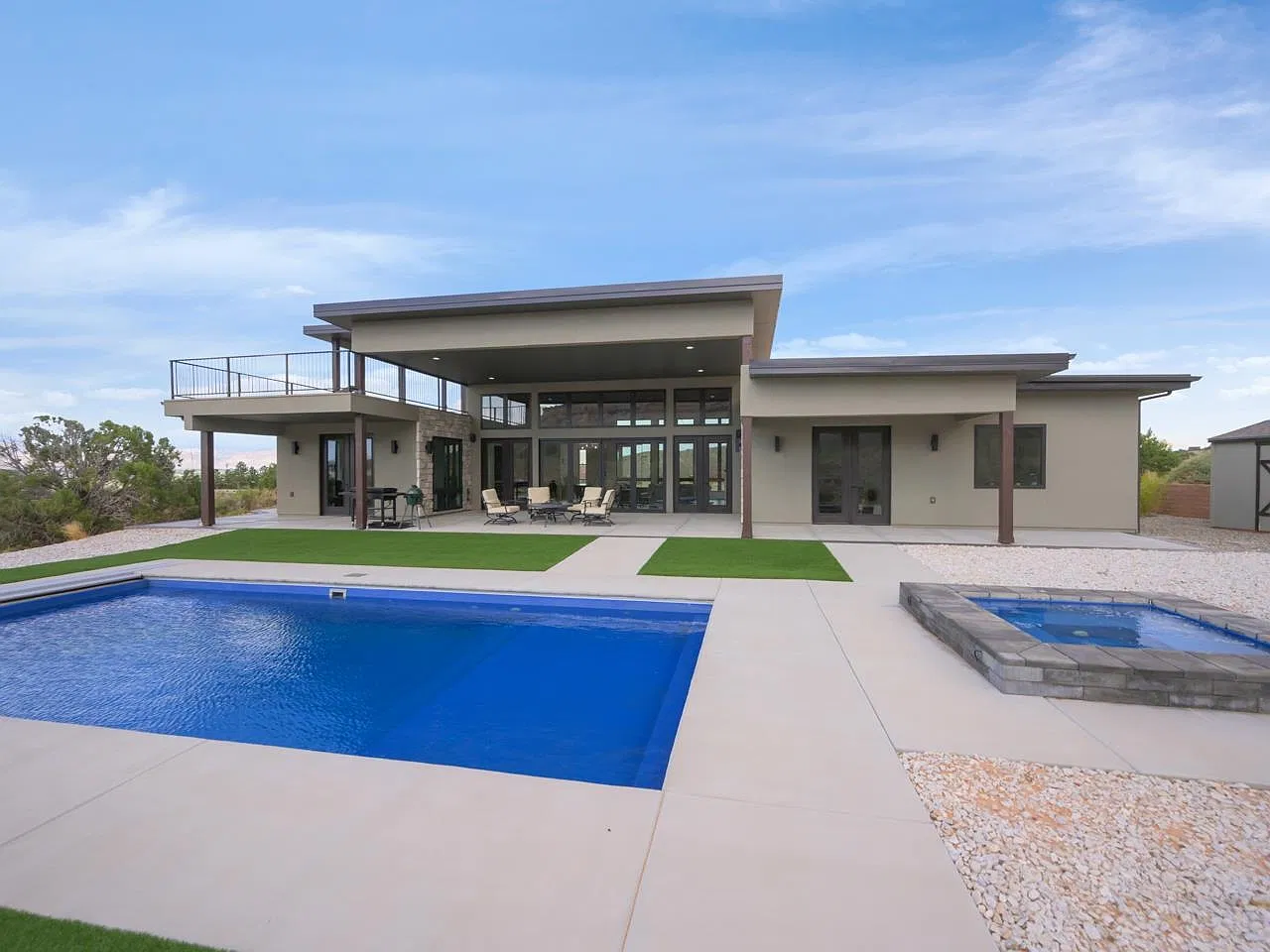 Back of the home with pool, hot tub and covered patio